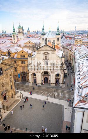 Prag, Tschechische Republik - 26. Dezember 2021: Panorama des Prager Klementinums und schneebedeckte Dächer im Winter, Tschechische Republik Stockfoto