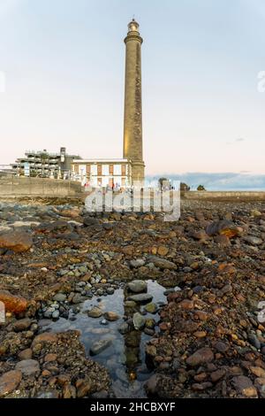 Leuchtturm an der felsigen Küste bei Sonnenuntergang in Maspalomas, Gran Canaria, Spanien Stockfoto