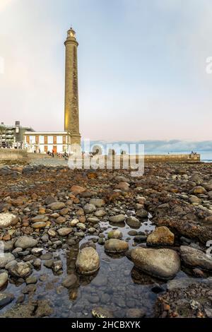 Leuchtturm an der felsigen Küste bei Sonnenuntergang in Maspalomas, Gran Canaria, Spanien Stockfoto