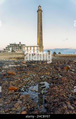 Leuchtturm an der felsigen Küste bei Sonnenuntergang in Maspalomas, Gran Canaria, Spanien Stockfoto