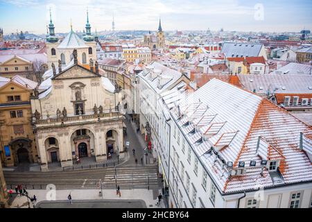 Prag, Tschechische Republik - 26. Dezember 2021: Panorama des Prager Klementinums und schneebedeckte Dächer im Winter, Tschechische Republik Stockfoto