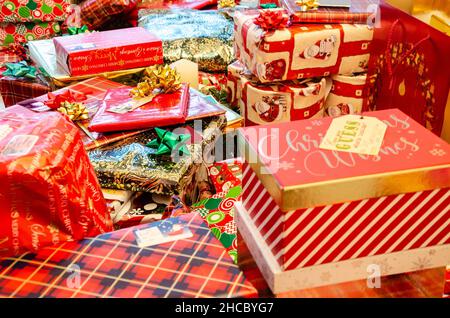 Stapel von Weihnachtsgeschenken, sorgfältig in festliches Papier eingewickelt und mit Schleifen und Bändern verziert. Stockfoto