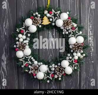 Weihnachtskranz auf grauem Holzhintergrund. Weihnachtsdekoration an der Tür Stockfoto