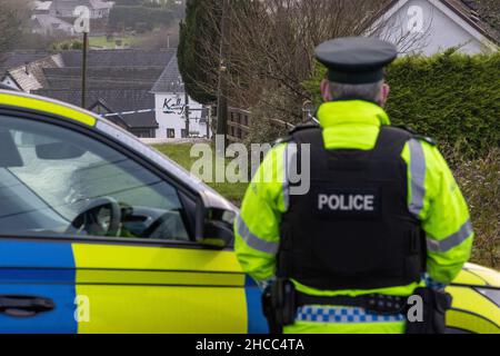 PSNI an der geschlossenen Radergan Road mit Blick auf Kellys Inn in der Omagh Road in Garvaghy, nachdem am Montag um etwa 1,50am Uhr drei Männer im Omagh Road-Gebiet getötet wurden und ein Auto und einen Lastwagen verwickelt waren. Bilddatum: Montag, 27. Dezember 2021. Stockfoto