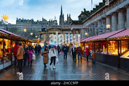 Edinburgh, Schottland, Großbritannien. 27th. Dezember 2021. Der Weihnachtsmarkt in Edinburgh wurde am zweiten Weihnachtsfeiertag mit neuen Regeln wiedereröffnet, um die Verbreitung der Omicron-Variante von Covid-19 zu verhindern, insbesondere wird nur ein Eingang verwendet, um die Anzahl zu heben. Besucher werden gebeten, vor dem Besuch einen seitlichen Durchflusstest durchzuführen. Tragen Sie eine Maske, halten Sie sich etwa 2m auseinander und folgen Sie den Schildern in den Gärten der East Princes Street. Abb. Die Besucherzahlen werden nach den neuen Vorschriften reduziert. Iain Masterton/Alamy Live News. Stockfoto