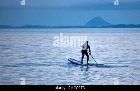 Portobello, Edinburgh, Schottland, Großbritannien. 27. Dezember 2021. Bewölkt am späten Nachmittag mit einer Temperatur von 5 Grad Celsius für diesen männlichen Power-Paddle-Boarder Sébastien, einen franzosen, der ursprünglich aus Marseille im Süden Frankreichs stammt und am Firth of Forth trainiert. Quelle: Archwhite. Stockfoto