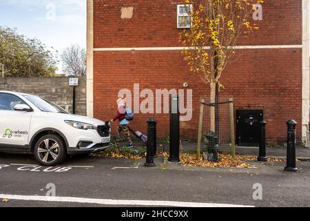 Ein Car Club mietet ein Auto an einer Ladestation für Elektroautos auf der Straße in einer Wohnstraße in Bristol. Stockfoto