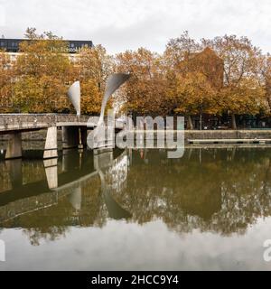 Bäume in Herbstfarben säumen die Uferhänge des schwimmenden Hafens von Bristol neben der Pero's Bridge. Stockfoto