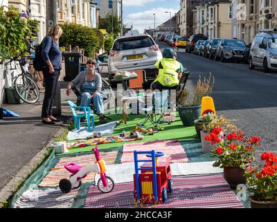 Bewohner und lebenswerte Aktivisten treffen sich in einem „Pop-up-Parklet“ auf einem umfunktionierten Parkplatz in einer Wohnstraße in Bristol. Stockfoto