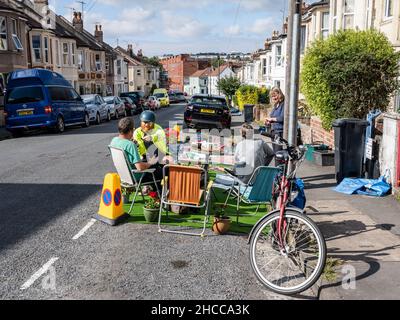 Bewohner und lebenswerte Aktivisten treffen sich in einem „Pop-up-Parklet“ auf einem umfunktionierten Parkplatz in einer Wohnstraße in Bristol. Stockfoto