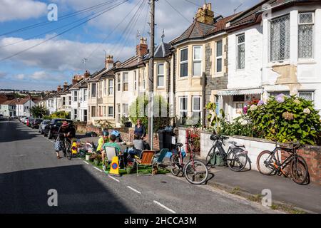 Bewohner und lebenswerte Aktivisten treffen sich in einem „Pop-up-Parklet“ auf einem umfunktionierten Parkplatz in einer Wohnstraße in Bristol. Stockfoto