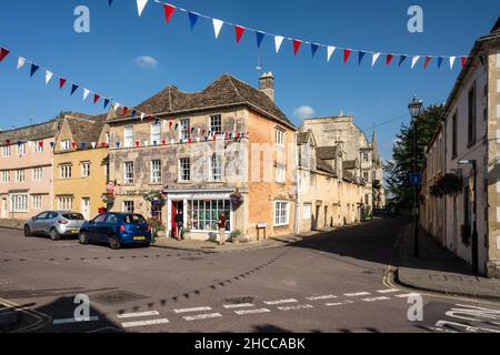 In der traditionellen High Street in der Marktstadt Corsham, Wiltshire, stehen die Käufer vor einem Postamt an. Stockfoto