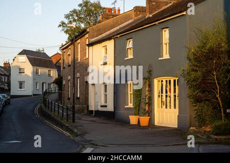 Traditionelle Hütten säumen die alte High Street von Fordington in Dorchester, Dorset. Stockfoto