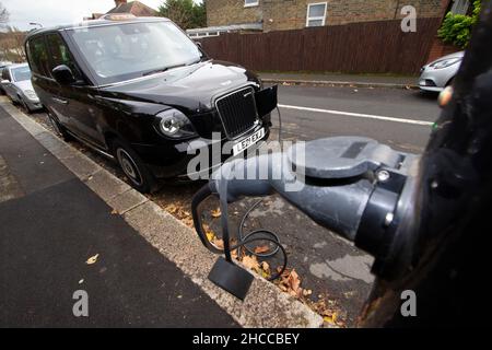 Ladestelle für Elektrofahrzeuge in der Londoner Straße mit DEM ELEKTROTAXI LEVC TX in Ladefunktion Stockfoto