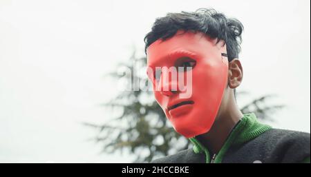 Junger südasiatischer Junge in einer gruseligen roten Maske in Indien Stockfoto