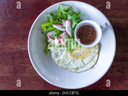 Gebratenes Eiweiß mit Salat und Sesam-Balsamico-Dressing gesundes Frühstück Stockfoto