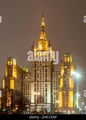 Blick in der Winternacht auf das stalinistische Hochhaus am Kudrinskaya-Platz mit Beleuchtung. Es ist eines von sieben stalinistischen Wolkenkratzern Stockfoto