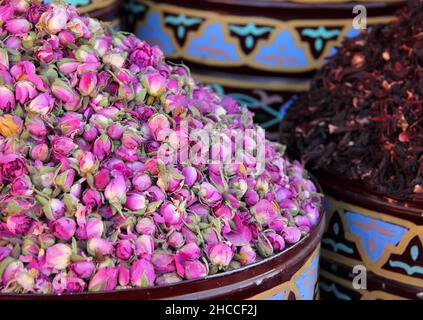 Farbenfrohe Darstellung von Rosenblüten und Blütenblättern im historischen Medina-Souk von Marrakesch. UNESCO-Weltkulturerbe. Stockfoto