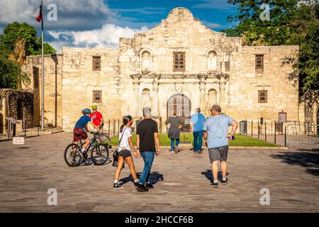 Vorbeifahrende Menschen vor der Alamo Mission in San Antonio Stockfoto