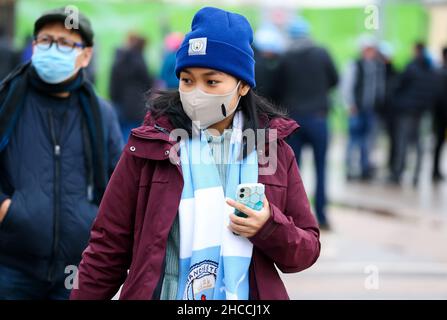 Manchester City-Fans mit schützenden Gesichtsmasken kommen zum Premier League-Spiel im Etihad Stadium in Manchester an. Bilddatum: Sonntag, 26. Dezember 2021. Stockfoto