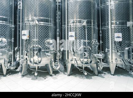 Gärtanks aus Edelstahl in einer Reihe in einer modernen Weinfabrik Stockfoto