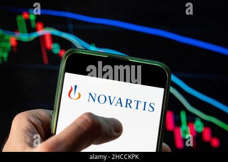 China. 09th Dez 2021. In dieser Abbildung ist das Logo des Schweizer multinationalen Pharmaunternehmens Novartis zu sehen, das auf einem Smartphone mit einem wirtschaftlichen Börsenindex im Hintergrund dargestellt ist. Kredit: SOPA Images Limited/Alamy Live Nachrichten Stockfoto