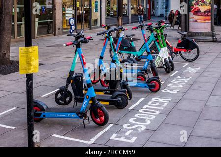 E-Scooter London - E-Scooter in ausgewiesenen Raum in Central London geparkt. Zugelassene E-Scooter zum Mieten in London. Stockfoto