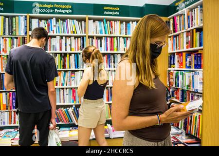 Valencia, Spanien; 6th. juli 2021: Maskierte Menschen in einem Buchladen während der Neuen Normalität Stockfoto