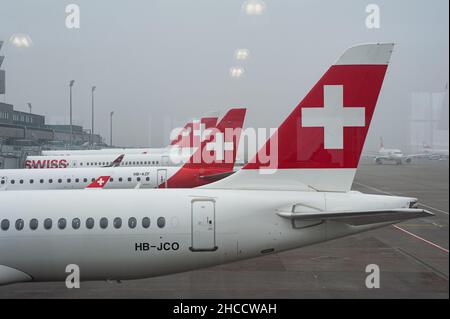 14.12.2021, Zürich, Schweiz, Europa - die Passagierflugzeuge von Swiss Airlines und Helvetic Airways stehen am Flughafen Zürich vor ihren Toren. Stockfoto