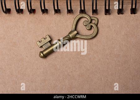 Draufsicht auf einen kleinen Schlüssel auf einem Notebook Stockfoto