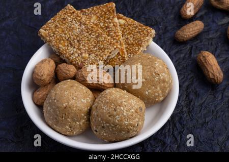 Indische traditionelle Süßigkeiten Mithai isoliert auf tiefblauem Hintergrund für Makar Sankranti Lohri Gajak, auch bekannt als Gur Gajjak Gazak Gachak Til Patti Stockfoto