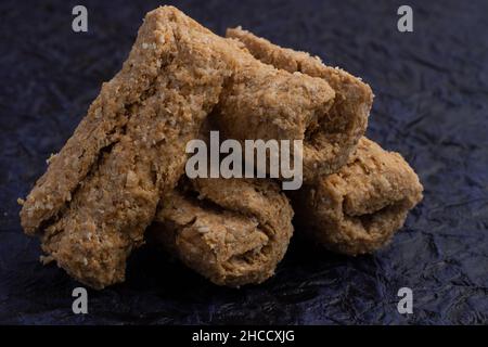 Indische Winter Delikatessen Süßigkeiten oder Mithai für Makar Sankranti oder Lohri Gajak auch bekannt als Gur Gajjak Gazak Gachak aus Sesamsamen bis zum Jaggery Stockfoto