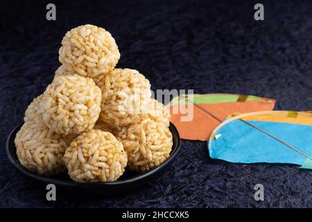 Winterliche Delikatesse Indische traditionelle Süßigkeiten oder Mithai mit Drachen für Makar Sankranti oder Lohri Puffreis Ball aus Jaggery til gul Sesam Stockfoto