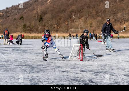 Valganna, Lombardei, Itay - Januari 19,2020: Kinder spielen in der Wintersaison Hockey im Torfmoor von Ganna. Campo Dei Fiori Regional Park in Provi Stockfoto