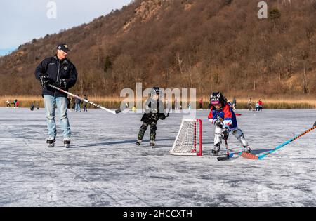 Valganna, Lombardei, Itay - Januari 19,2020: Vater mit Kindern spielt in der Wintersaison Hockey im Torfmoor von Ganna. Campo Dei Fiori Regional P Stockfoto