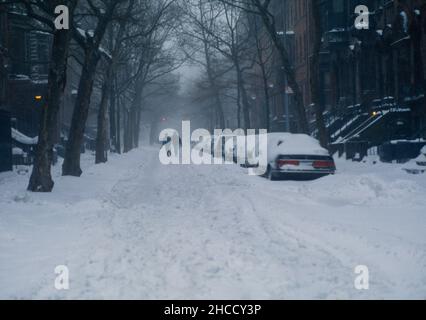 Zwei Personen, die während eines Schneesturms im Park Slope Brooklyn NYC die Straße entlang laufen Stockfoto