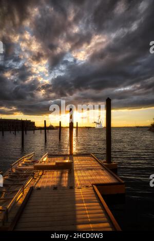 Blick auf den alten hölzernen Pier über das Meerwasser bei schönem Sonnenuntergang Stockfoto