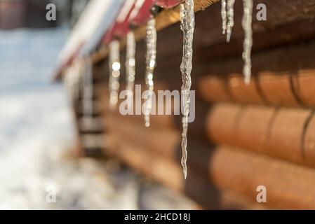 Eiszapfen auf dem Dach schmelzen in der Frühlingssonne Stockfoto