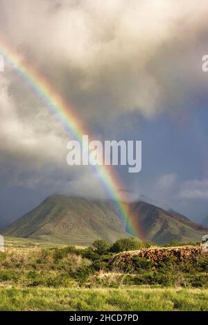 Vertikale Landschaft eines Regenbogens, der über die westlichen maui-Berge schlenzt. Stockfoto