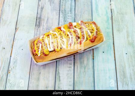 Der Hot Dog ist eine Kombination aus gekochter oder gebratener Wiener Wurst, die auf einem langen Brötchen serviert wird, das oft von einem Belag wie Ketchup, Mustar begleitet wird Stockfoto