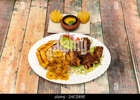 La Fritada ist ein typisches Gericht der Gastronomie Ecuadors, seine Hauptkomponente ist gebratenes Schweinefleisch. Es ist ein traditionelles Essen aus dem ecuadorianischen Hochland. Stockfoto