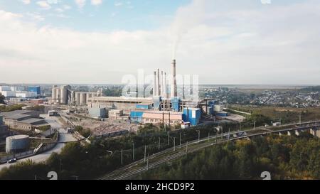 Industriegebiet und Rauchkamin auf Kraftwerk in der Nähe der Stadt. Landschaft. Rauchschwaden aus Kesselrohren auf Heizanlage, Luftaufnahme, Ökologie konz Stockfoto