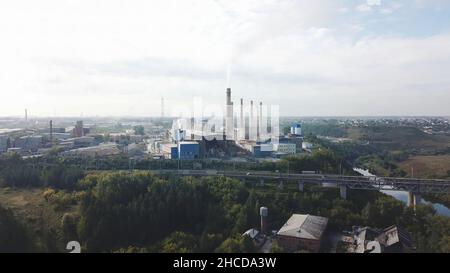 Industriegebiet und Rauchkamin auf Kraftwerk in der Nähe der Stadt. Landschaft. Rauchschwaden aus Kesselrohren auf Heizanlage, Luftaufnahme, Ökologie konz Stockfoto