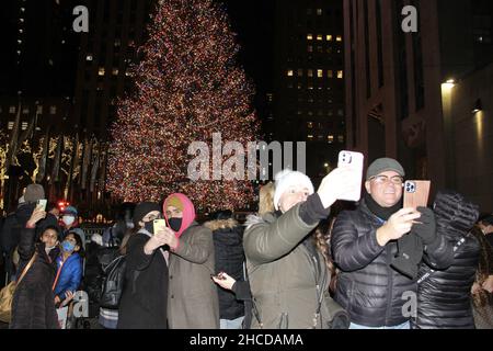 Neu, USA. 27th Dez 2021. (NEUER) Rockefeller Weihnachtsbaum und seine Attraktionen. 27. Dezember 2021, New York, USA: Der Rockefeller-Weihnachtsbaum, der am 1. Dezember 2021 offiziell der Öffentlichkeit vorgestellt wurde, zieht weiterhin New Yorker und Touristen an. Schwere Sicherheit mit Zäunen von NYPD hilft, jede Verwirrung oder Gefahr einzudämmen, während die Menschen die Gelegenheit nutzen, Fotos zu machen, zu bewundern und sogar mit der Möglichkeit, im Rockefeller Center Ski zu fahren. Die meisten Menschen verwenden Gesichtsmasken. (Bild: © Niyi Fote/TheNEWS2 via ZUMA Press Wire) Stockfoto