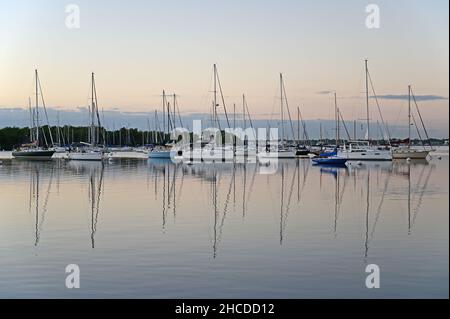 Miami, Florida - 27. Dezember 2021 - festgemacht Segelboote und ihre Reflexionen vor Kenneth M Myers Park in Coconut Grove im Morgenlicht. Stockfoto