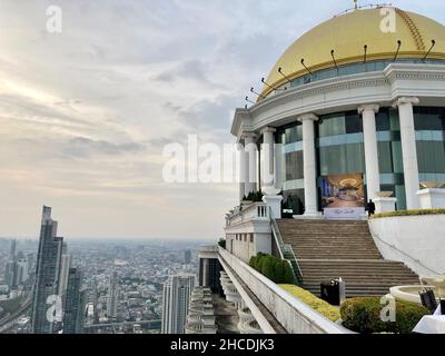 Bangkok, Thailand. 19th Dez 2021. Die imposante Sky Bar des Scirocco Restaurants mit seiner markanten Goldkuppel ist vor allem für den Film 'Hangover 2' bekannt. Es befindet sich auf der 64th. Etage. Der Blick über Bangkok ist atemberaubend. Die Bar zieht zahlreiche Gäste aus der ganzen Welt an, auch wegen des Films, und vermarktet den Ruhm unter anderem mit einem Signature-Drink namens 'Hannovertini'. Quelle: Carola Frentzen/dpa/Alamy Live News Stockfoto