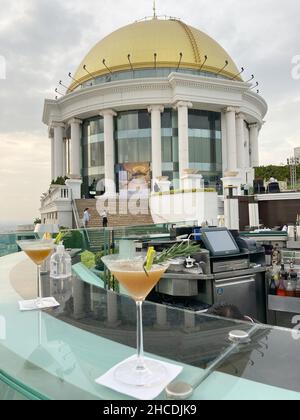 Bangkok, Thailand. 19th Dez 2021. Zwei 'Hannovertinis' in der beeindruckenden Sky Bar des Scirocco Restaurants. Der Cocktail ist das Markenzeichen der Bar, benannt nach dem Film 'Hangover 2', der hier teilweise gedreht wurde. Die Bar mit ihrer markanten goldenen Kuppel befindet sich auf der 64th. Etage. Der Blick über Bangkok ist atemberaubend. Auch wegen des Films kommen bis heute zahlreiche Gäste aus aller Welt. Quelle: Carola Frentzen/dpa/Alamy Live News Stockfoto