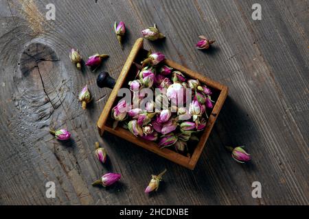 rosebuds in einer Holzschublade auf einem rustikalen Holzhintergrund Stockfoto