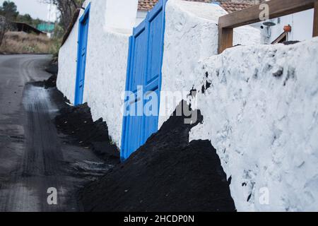 Vulkanische Asche auf den Straßen in städtischer Umgebung nach einem Ausbruch. Asche und Schlacke, feste Lava der postapokalyptischen Vulkanlandschaft Stockfoto