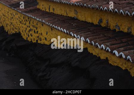 Vulkanische Asche auf den Straßen in städtischer Umgebung nach einem Ausbruch. Asche und Schlacke, feste Lava der postapokalyptischen Vulkanlandschaft Stockfoto